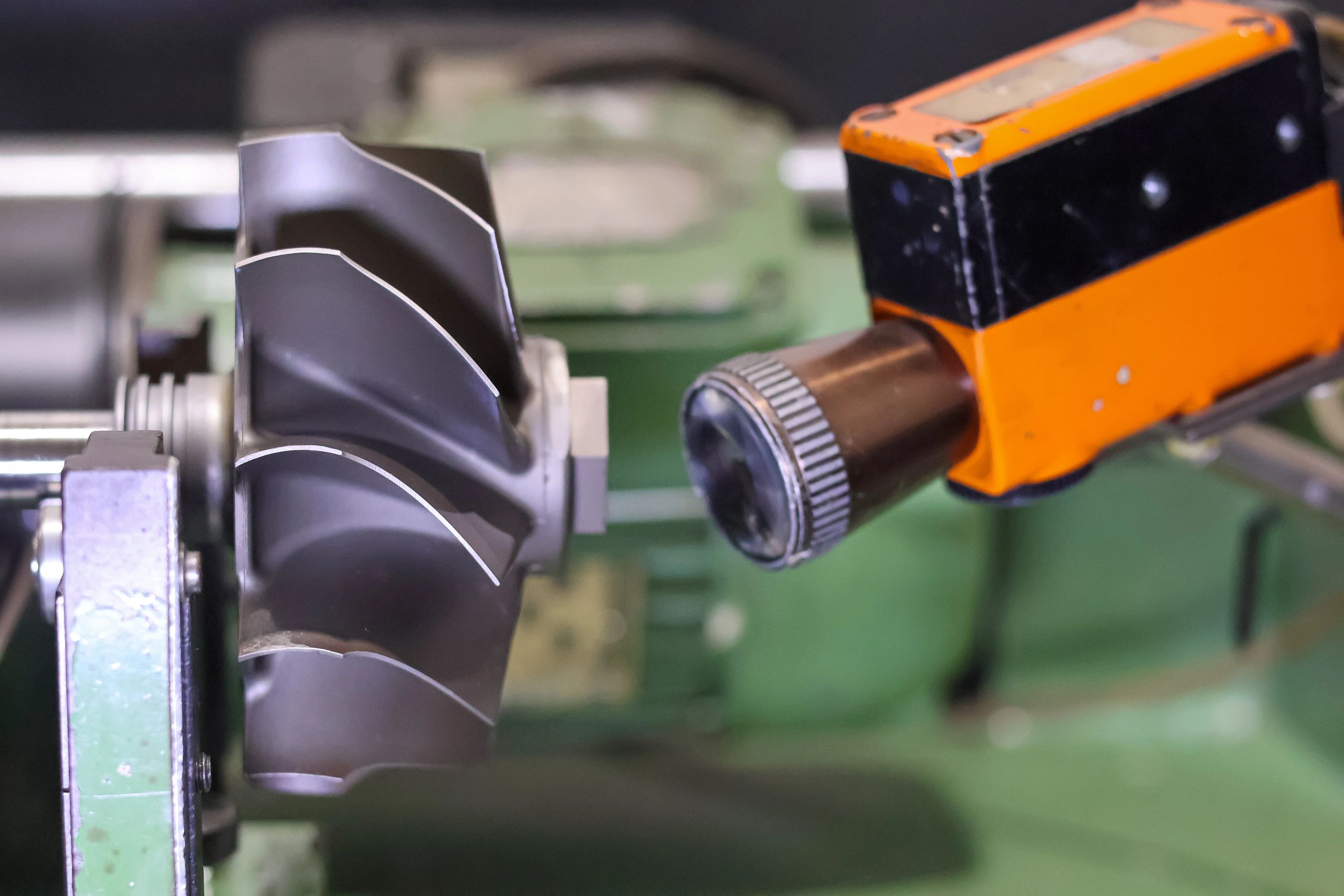 Sensor de precisión midiendo componente metálico industrial